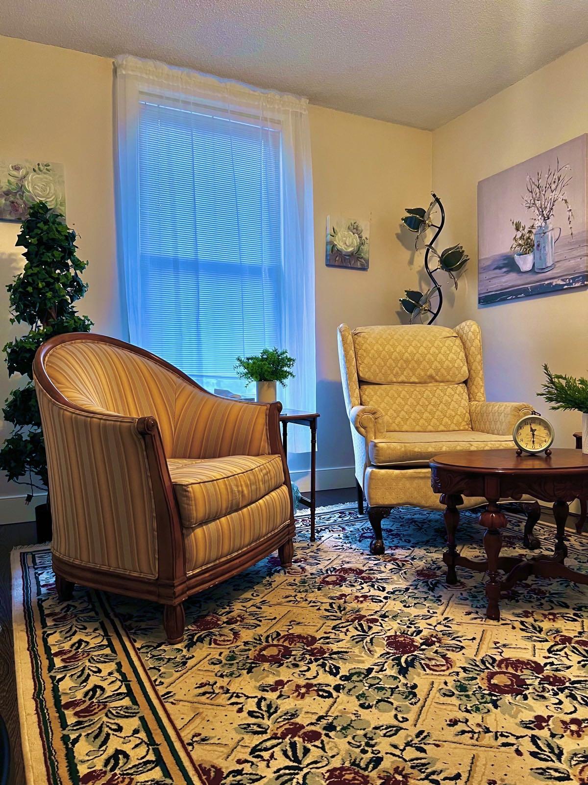 Therapy sitting room with armchairs, a coffee table, and natural light